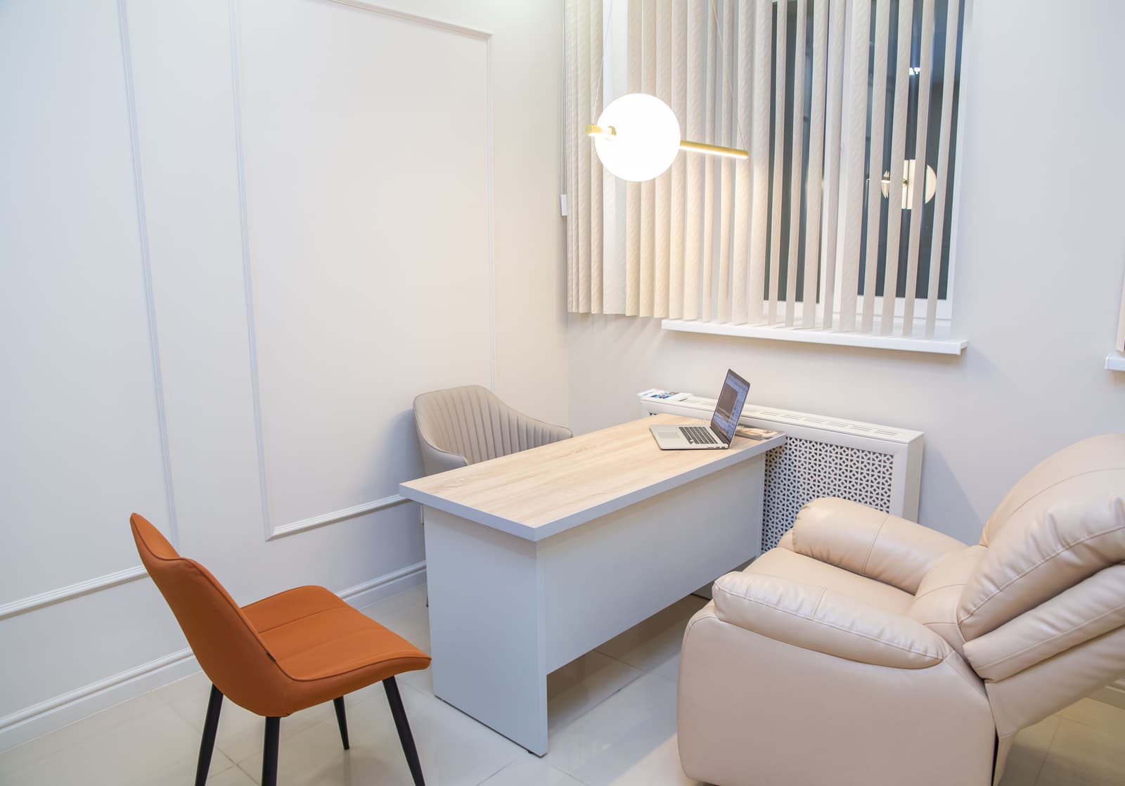 The check-in desk at Fieldgate, with a pendant light and a chair beside it.